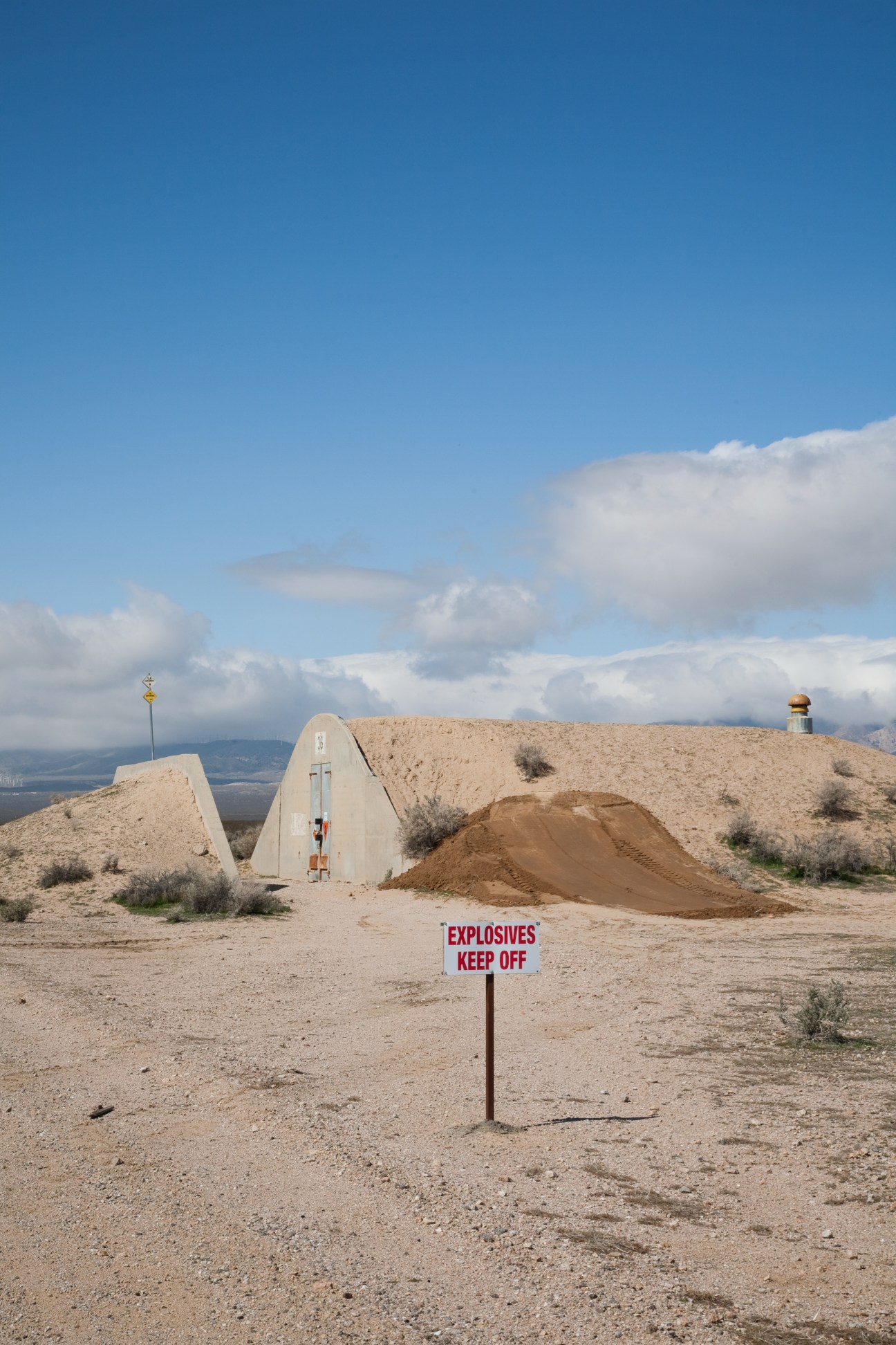 Second World War era bunker at Mojave Air and Space Port with 'Explosives Keep Off' sign in desert landscape.