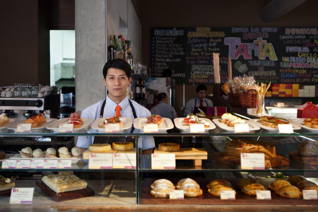 Staff member at Tanta bakery counter displaying pastries and baked goods