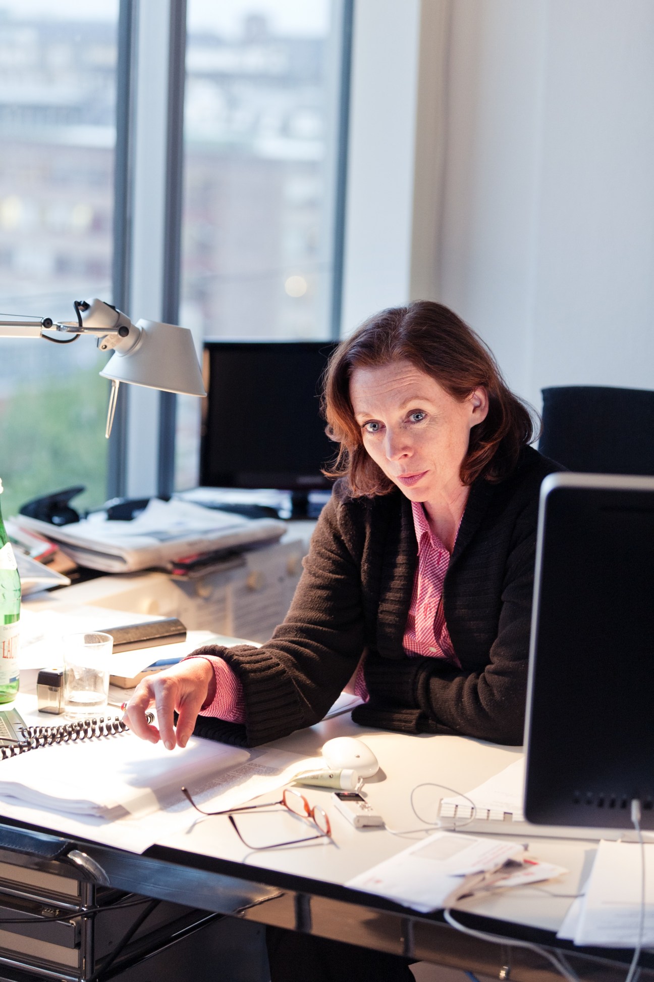 Britta Sandberg, editor of the foreign desk at Der Spiegel, sits at her desk in a high-rise office with city views.