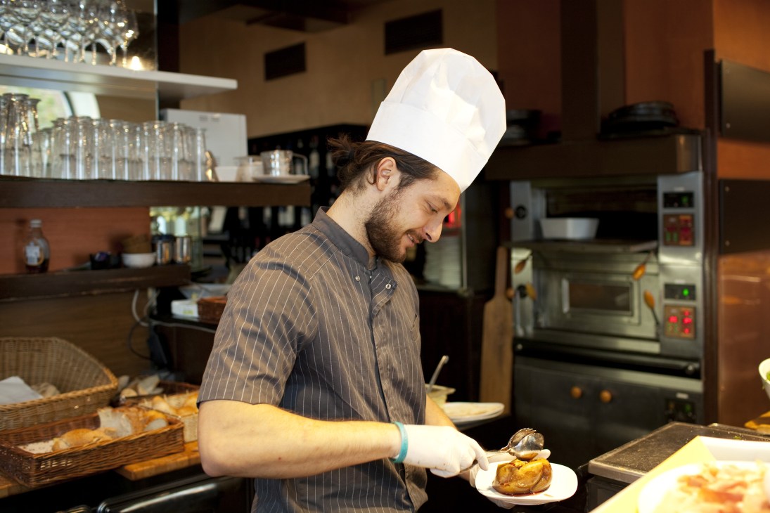 Chef plating pastry at Doppio Zero bakery/restaurant kitchen counter.