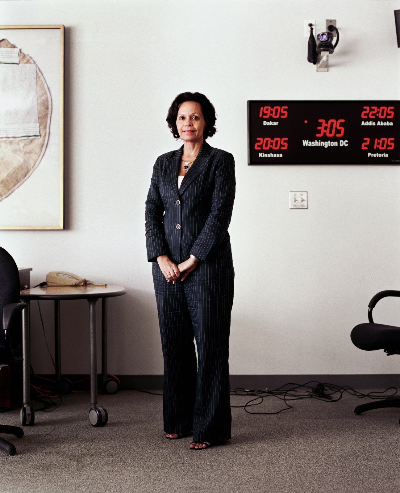 Elizabeth Lule, Managing Director of the World Bank AIDS Campaign Team for Africa, stands in an office with a world clock on the wall behind her.