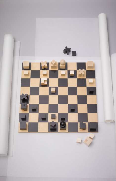Naef wooden chess set with natural and dark pieces arranged on alternating light and dark squares.