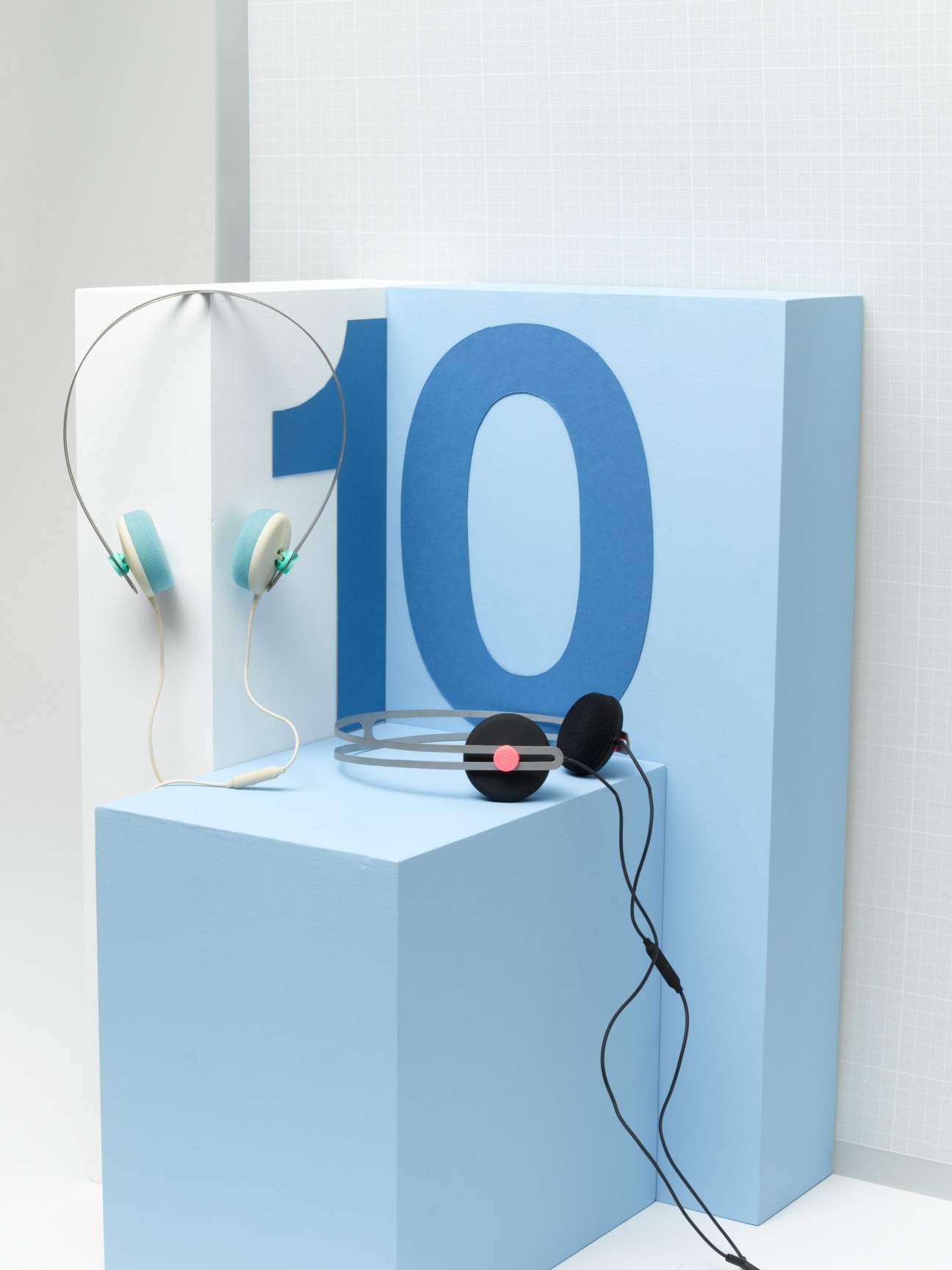 AIAIAI Tracks headphones displayed on blue cube with circular mirror backdrop and large blue numeral 10.