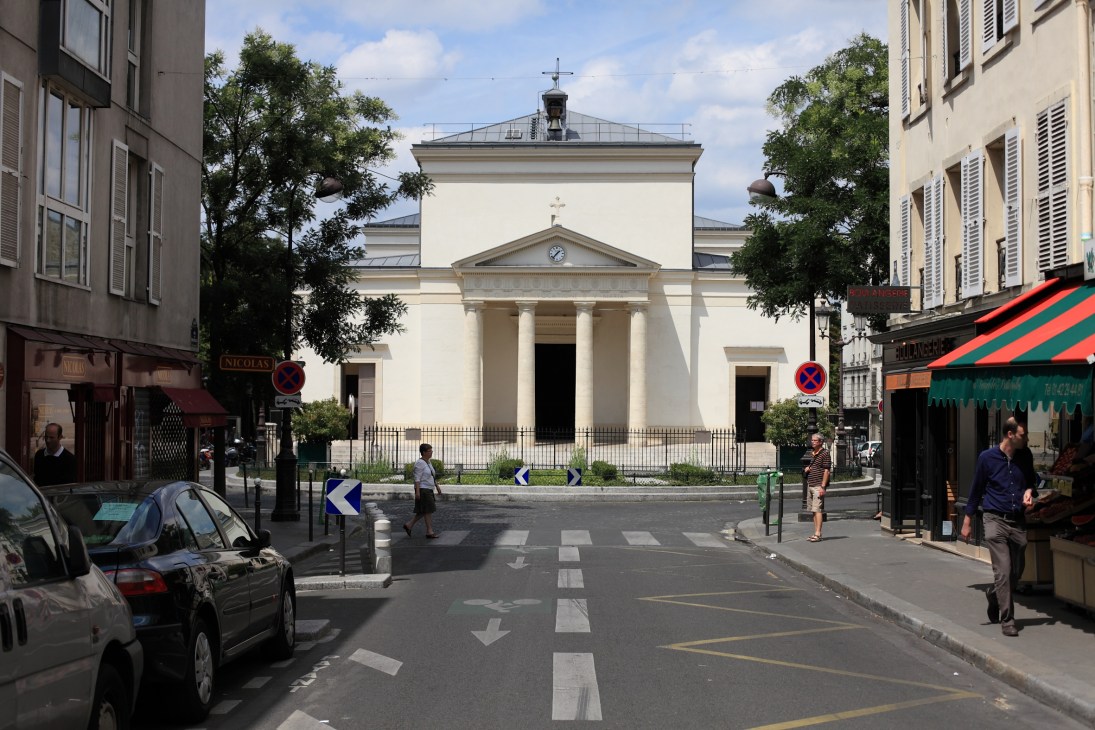 Church Sainte Marie des Batignolles with white neoclassical facade and cross on roof in Paris street square.