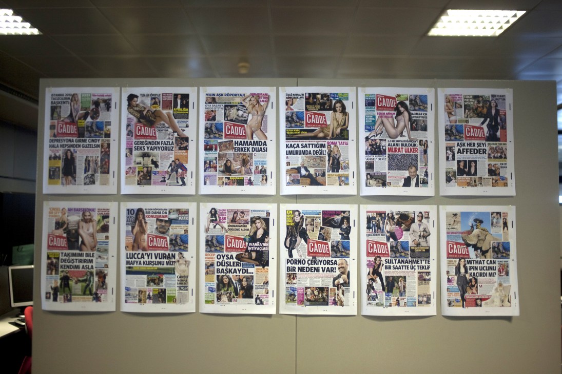 Display of colorful Turkish newspaper front pages with celebrity coverage and bold headlines mounted on a wall.