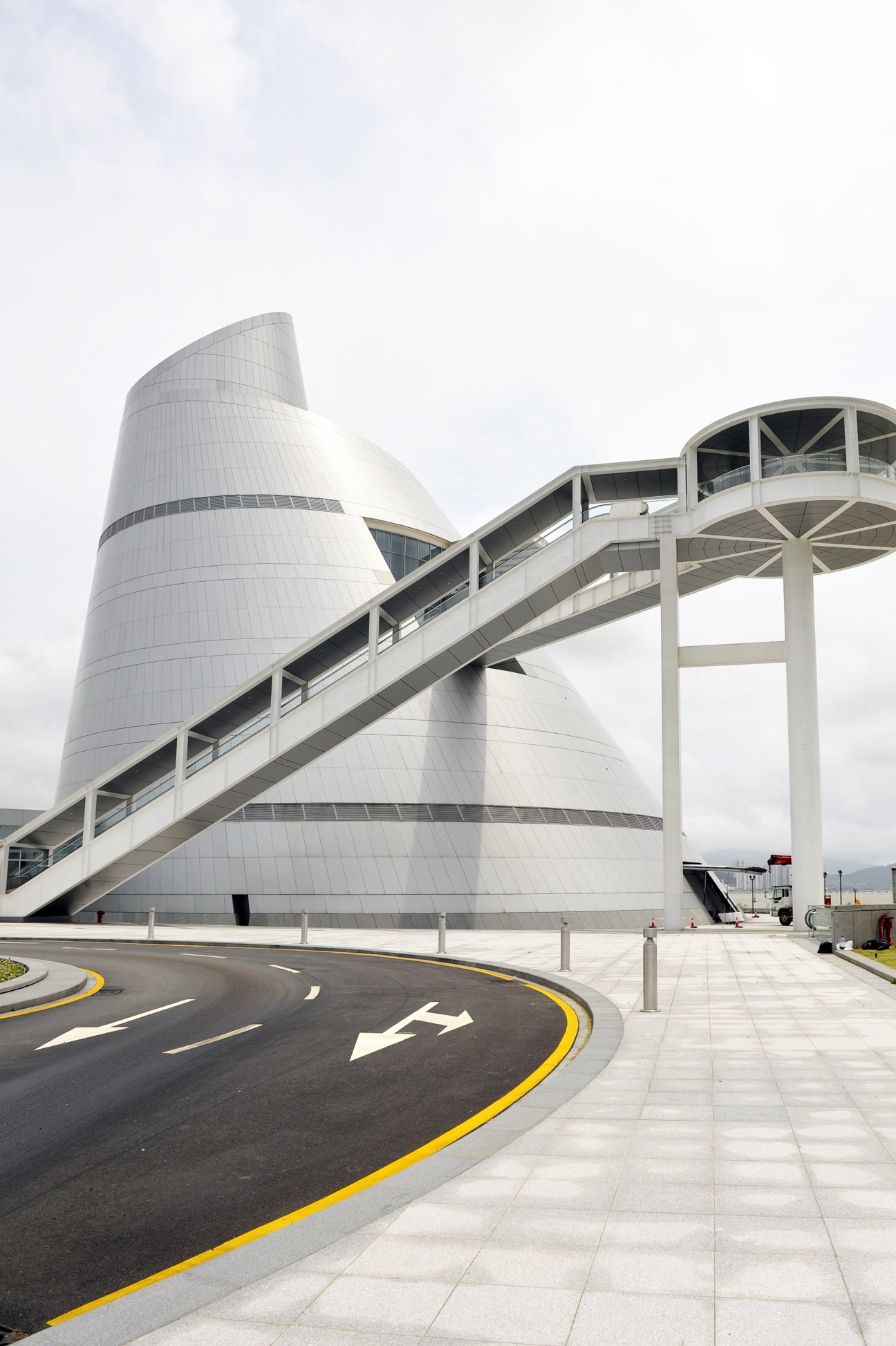 IM Pei's Macau Science Centre with white cylindrical tower and curved walkway.