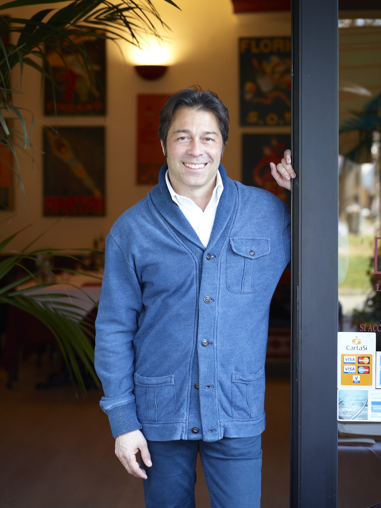 Paolo Introini, owner of Sant'Eustorgio restaurant, smiling outside the restaurant entrance.