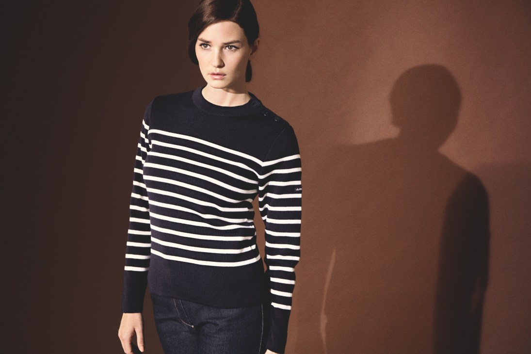 Woman wearing a black and white striped merino wool sweater with horn buttons.
