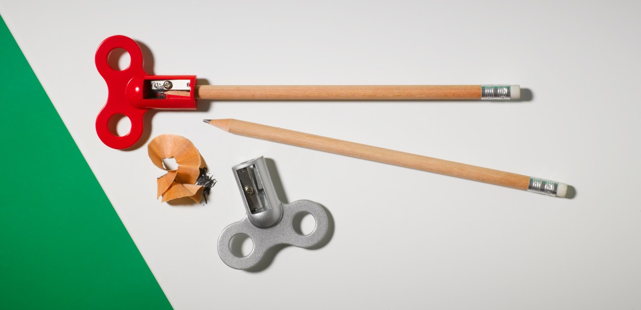 Noam Bar Yochai's Turnkey pencil sharpeners in red and grey metal with wooden pencils and shavings.