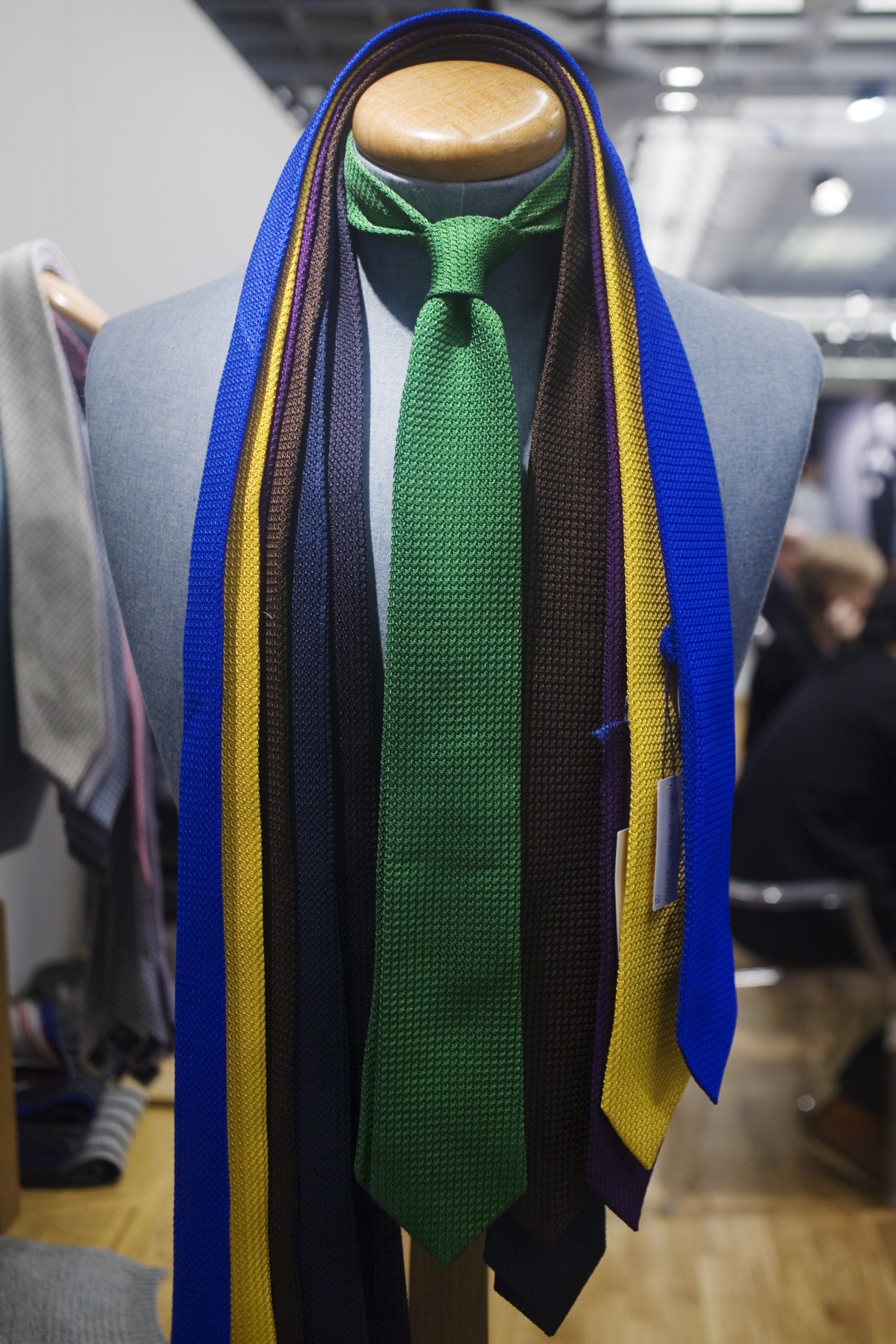 Drakes knit ties and scarves displayed on a mannequin at Pitti Uomo menswear show.