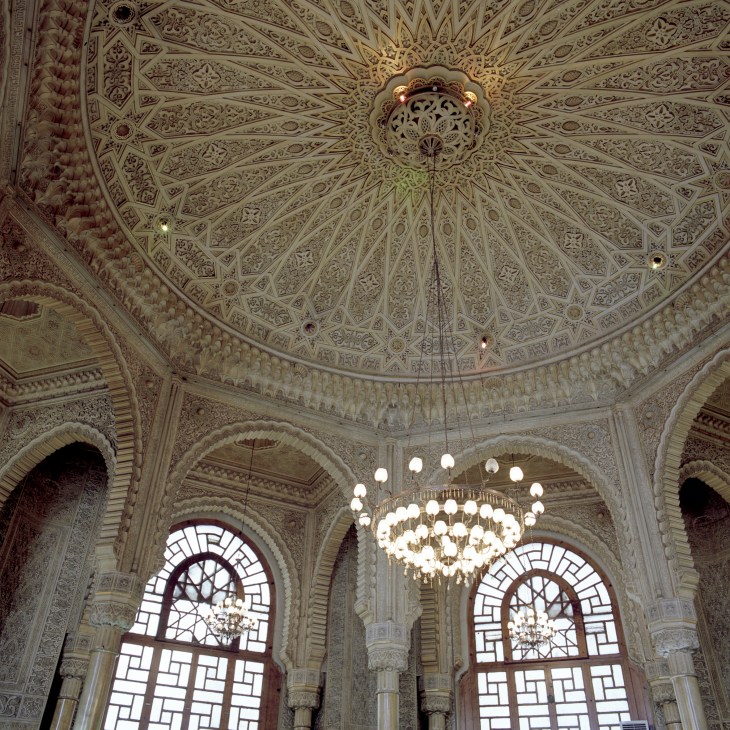 Ornate interior ceiling of Grande Poste with intricate geometric patterns and central chandelier.