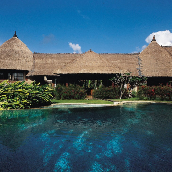 Tugu Hotel's thatched-roof suites with pool overlooking tropical gardens in Canggu, Bali.