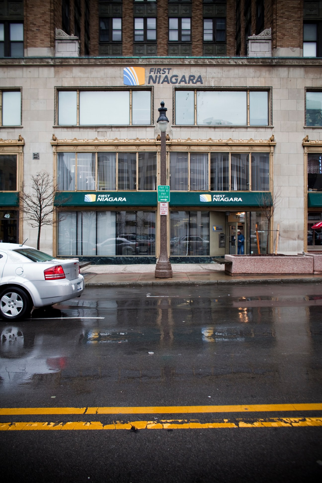 A First Niagara Bank storefront in a historic brick building on a wet street.