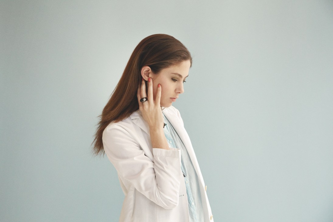 Woman wearing white blazer and jewelry designed by Vibe Harsløf, Copenhagen.