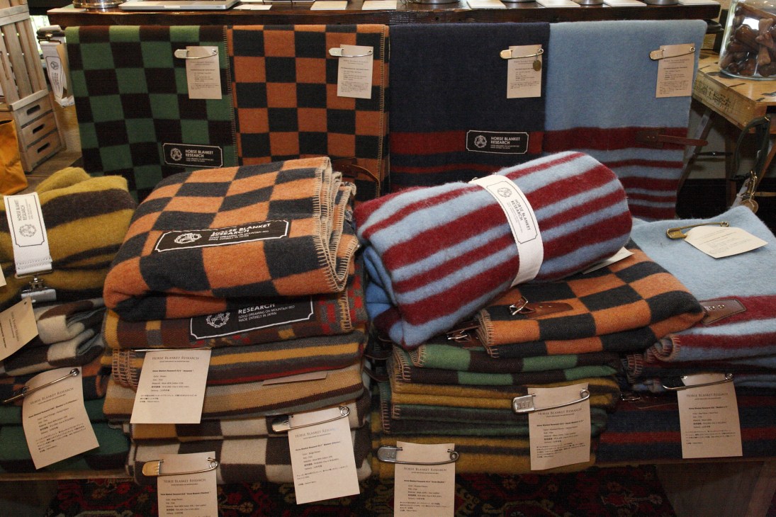 Horse Blanket Research wool and cotton blankets displayed with checkered and striped patterns in various colors.