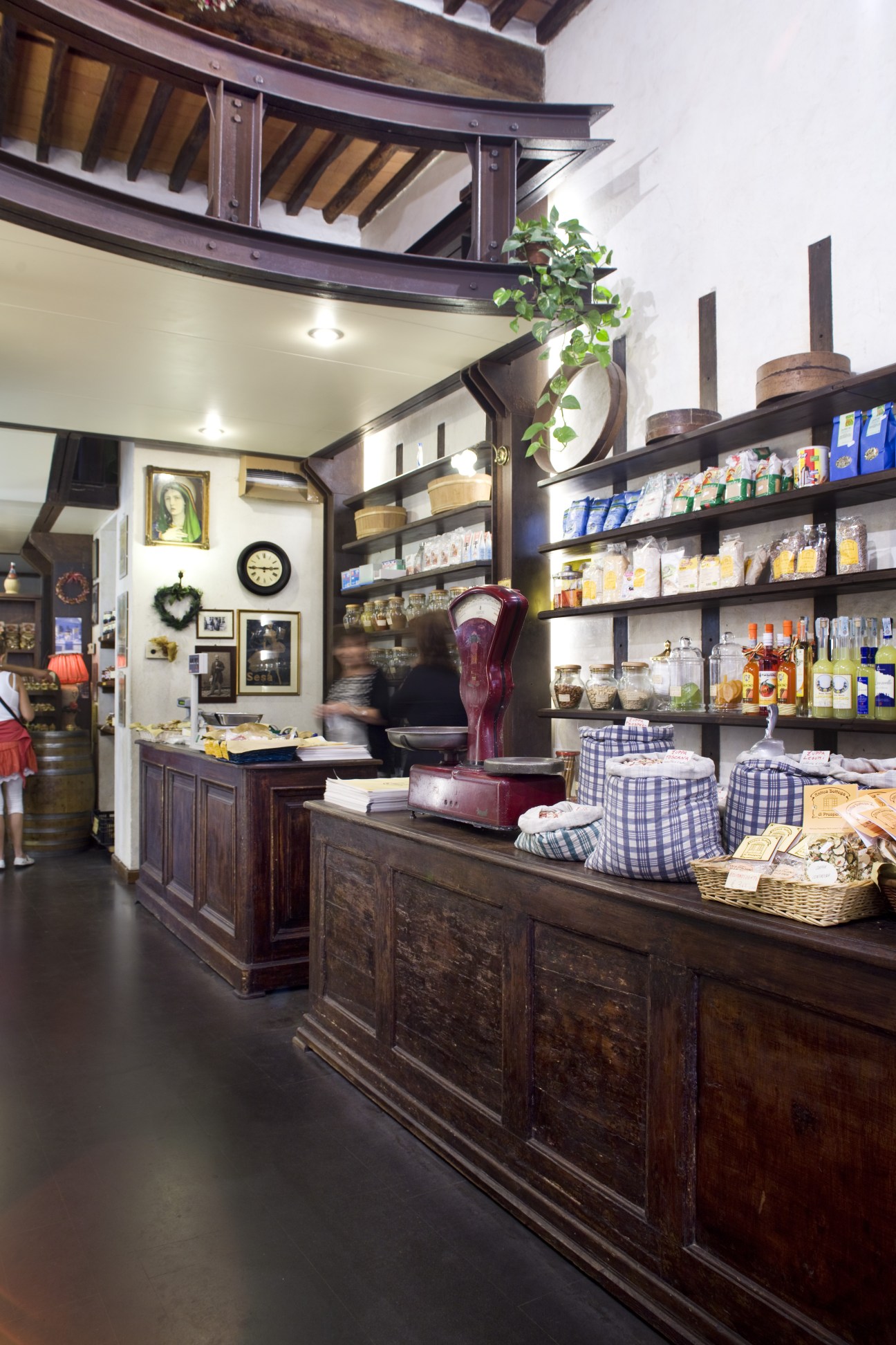 Interior of Prospero food store with dark wood counter, shelves of packaged goods, and traditional architectural details.