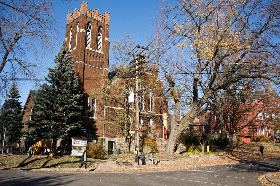 A brick church with a tall tower on a tree-lined street in Toronto's Junction neighbourhood.