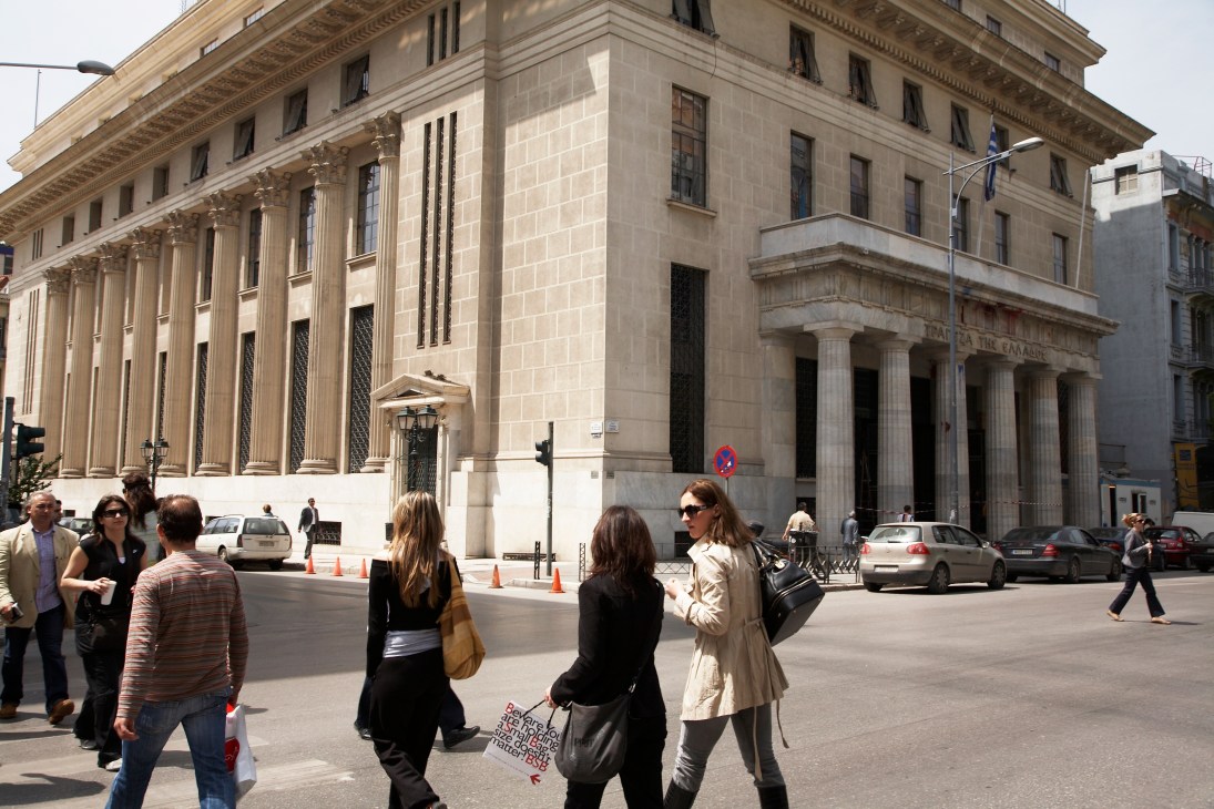 National Bank of Greece headquarters with neoclassical marble columns and people walking in front.