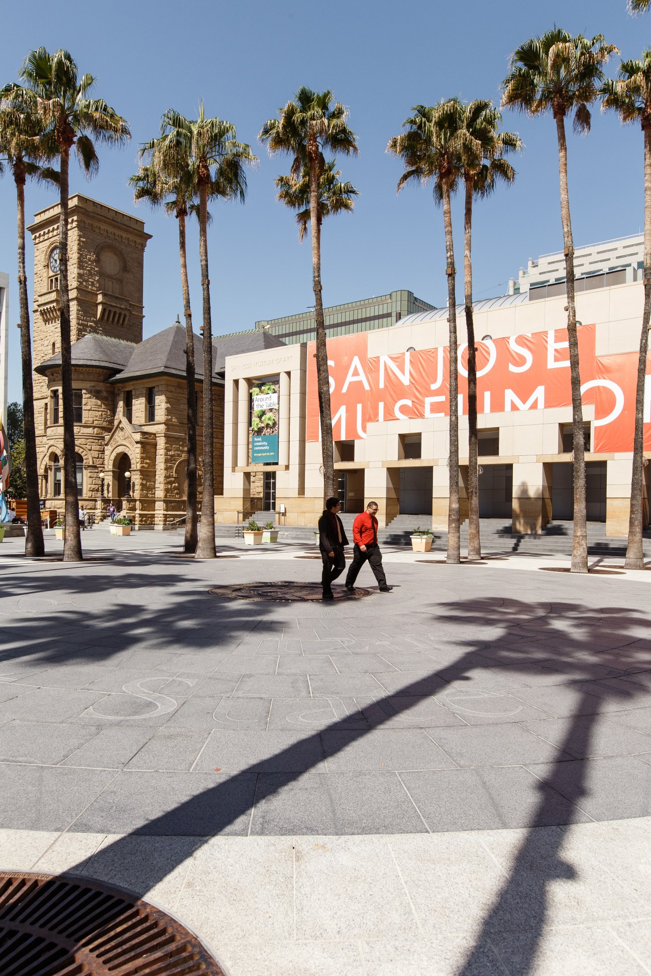 San Jose Museum of Art exterior with palm trees, historic clock tower, and modern building facade.