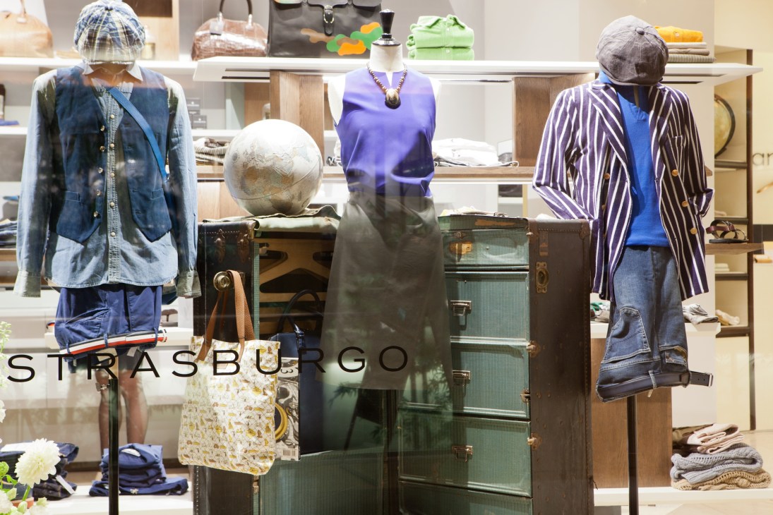 Strasburgo retail store interior with mannequins displaying clothing and accessories against shelving.