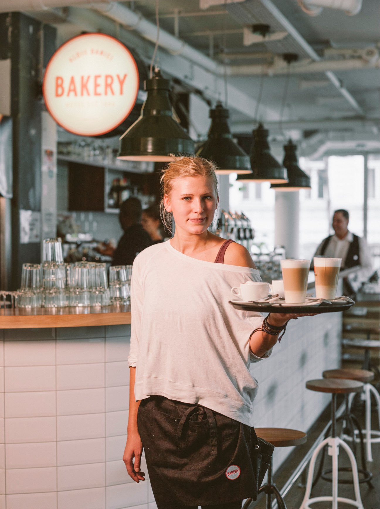 Woman serving coffee and pastries at Hotel Daniel Vienna's bakery cafe