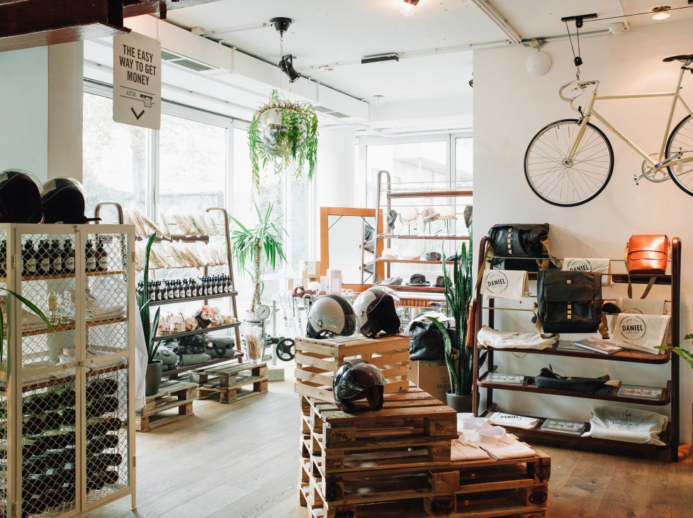 Hotel Daniel Vienna lobby with bicycle, plants, wooden pallets, and retail displays