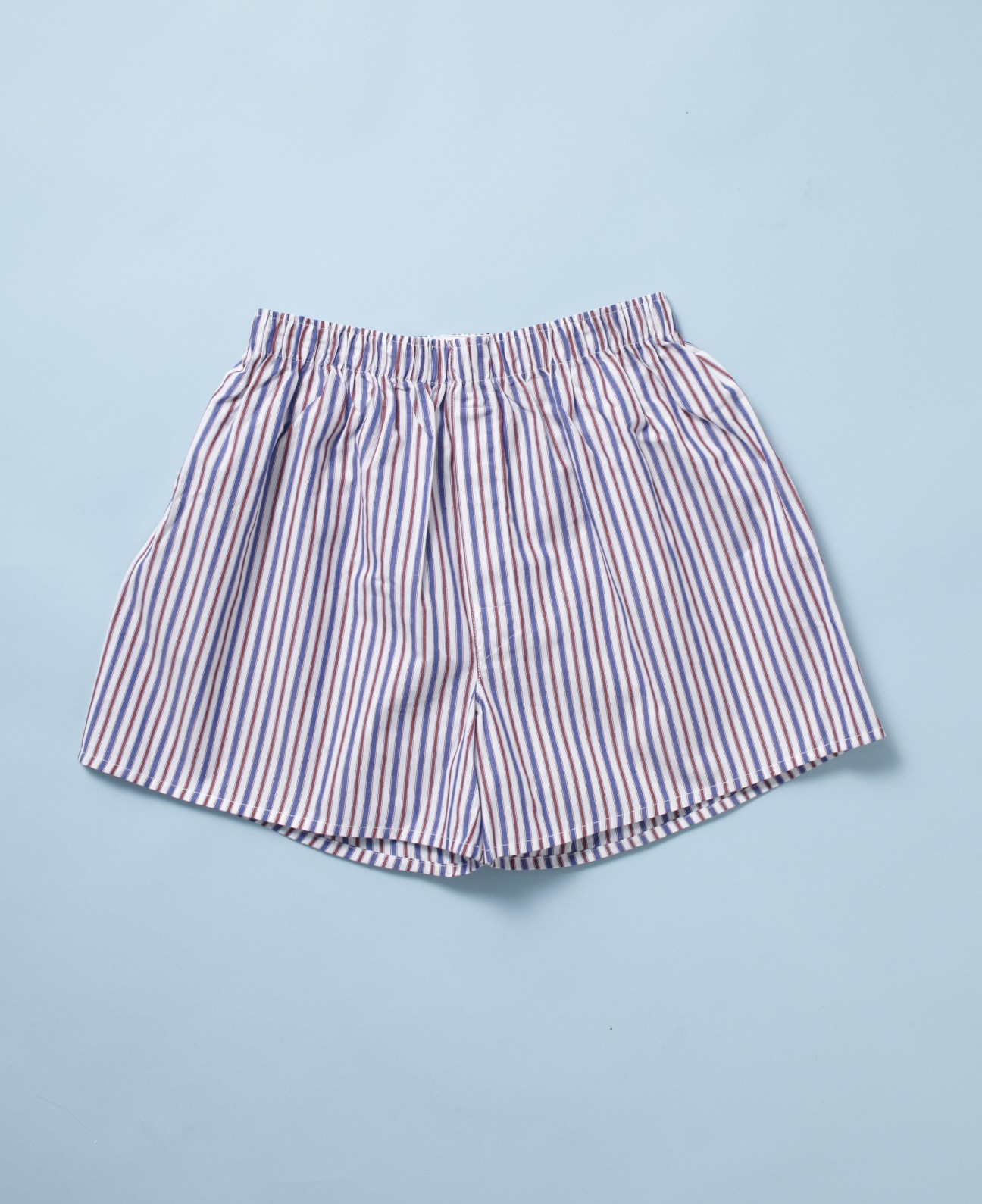 Sunspel striped boxers with blue and white vertical stripes on light blue background.