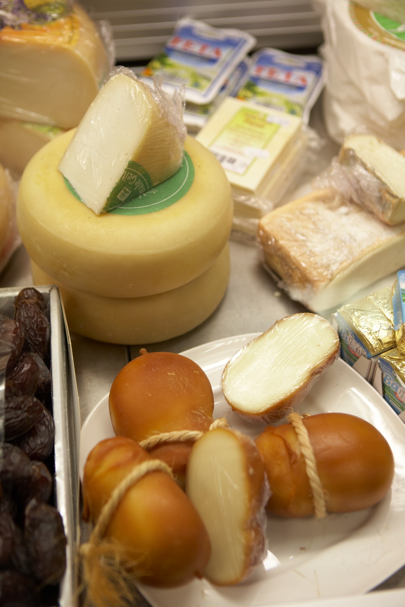 Gaia supermarket cheese counter displaying various Dutch cheeses including round wheels and sliced varieties.