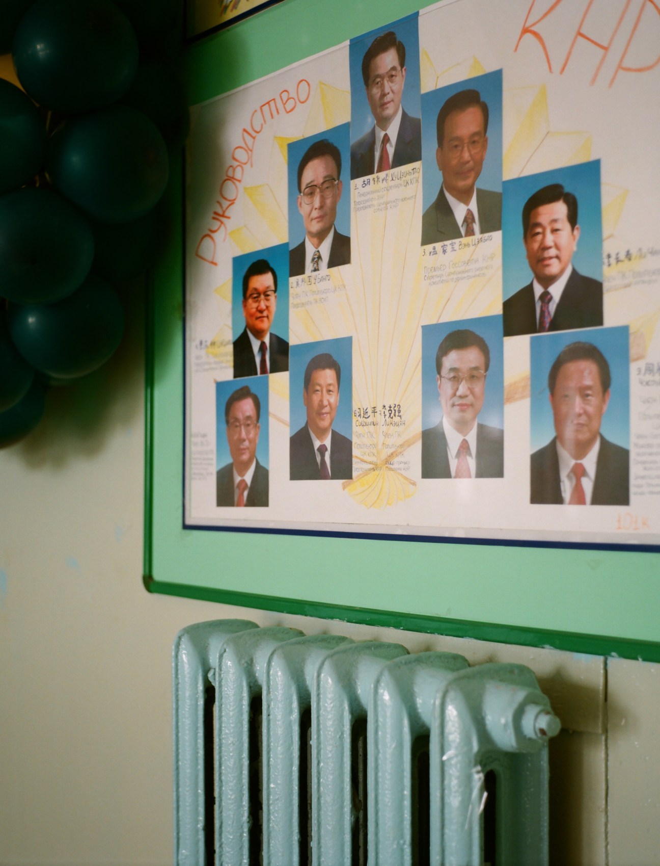 Multiple portrait photographs of Chinese leaders displayed on a wall at Blagoveshchensk Pedagogical University.