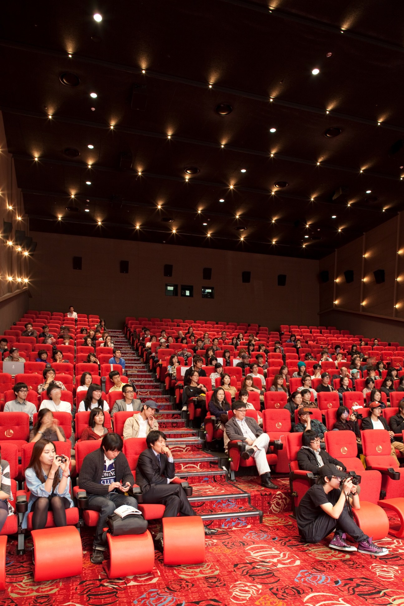 Audience seated in red theater chairs during a Q&A session at a film festival screening.