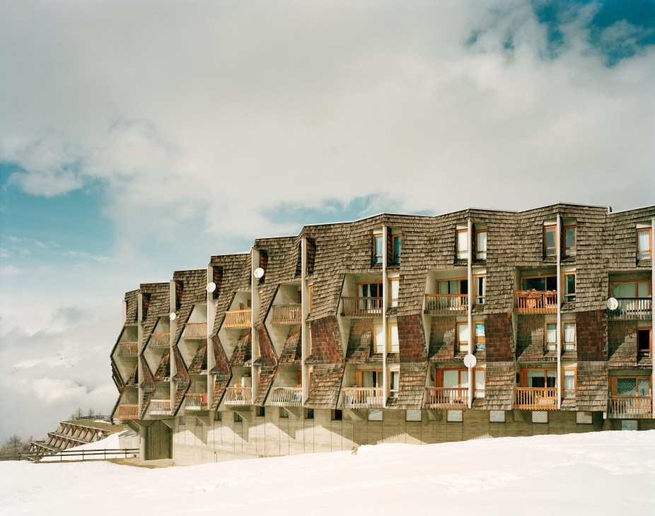 Modern ski resort accommodation building with distinctive angular architecture set in snowy landscape.