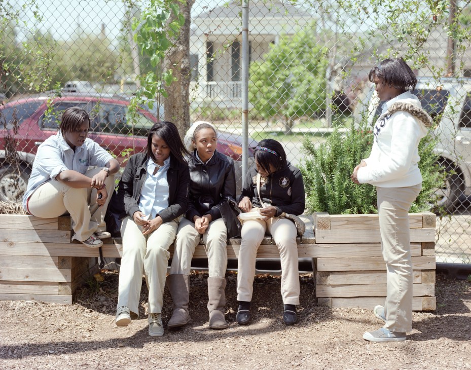 International High School students socializing during lunch break in an outdoor courtyard area.