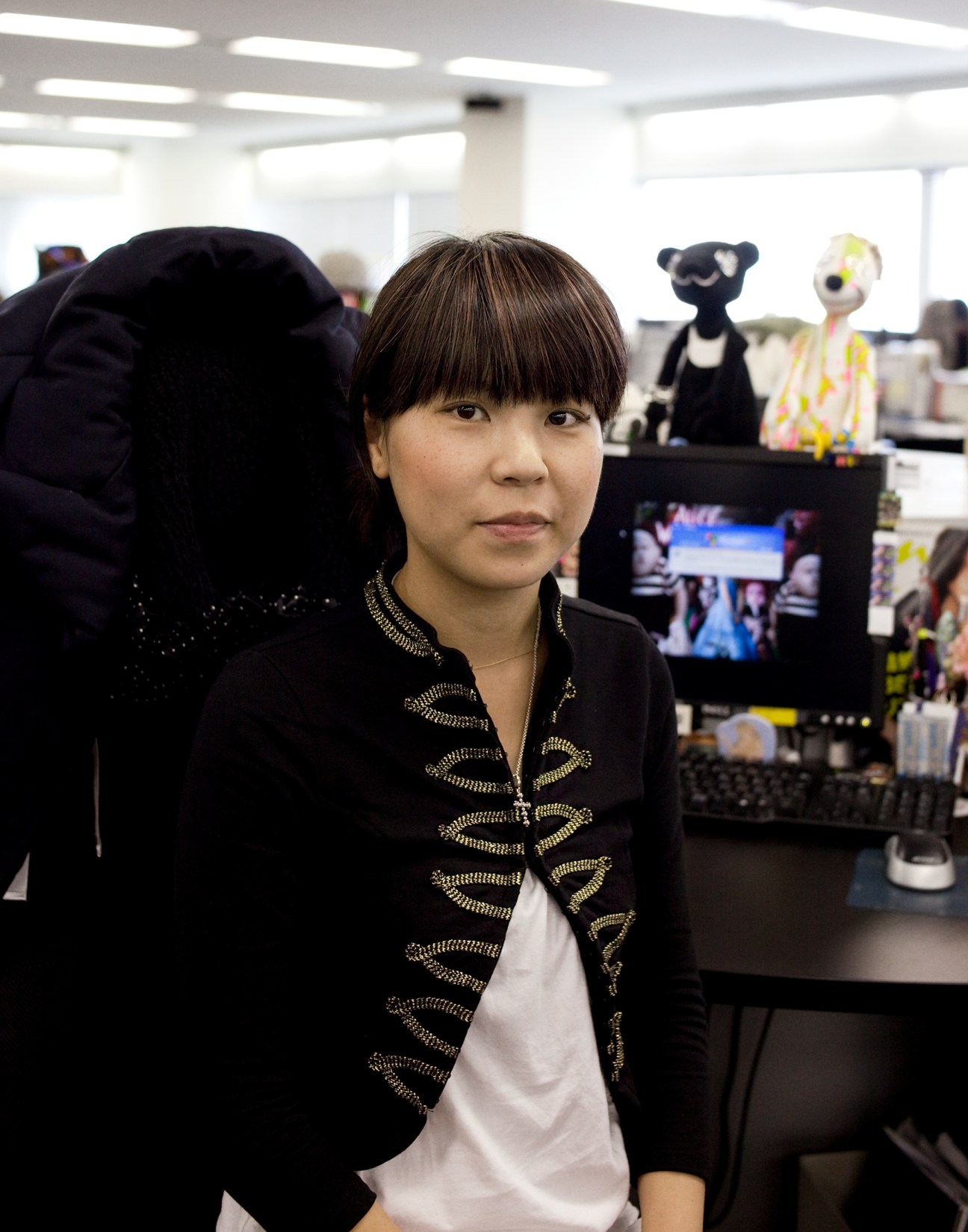 Chie Ogawa, a 27-year-old buyer at Start Today, stands in the office wearing a black jacket with gold embroidery.