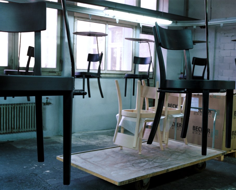 Horgenglarus Classic wooden chairs in black and natural finish displayed in factory paint shop.