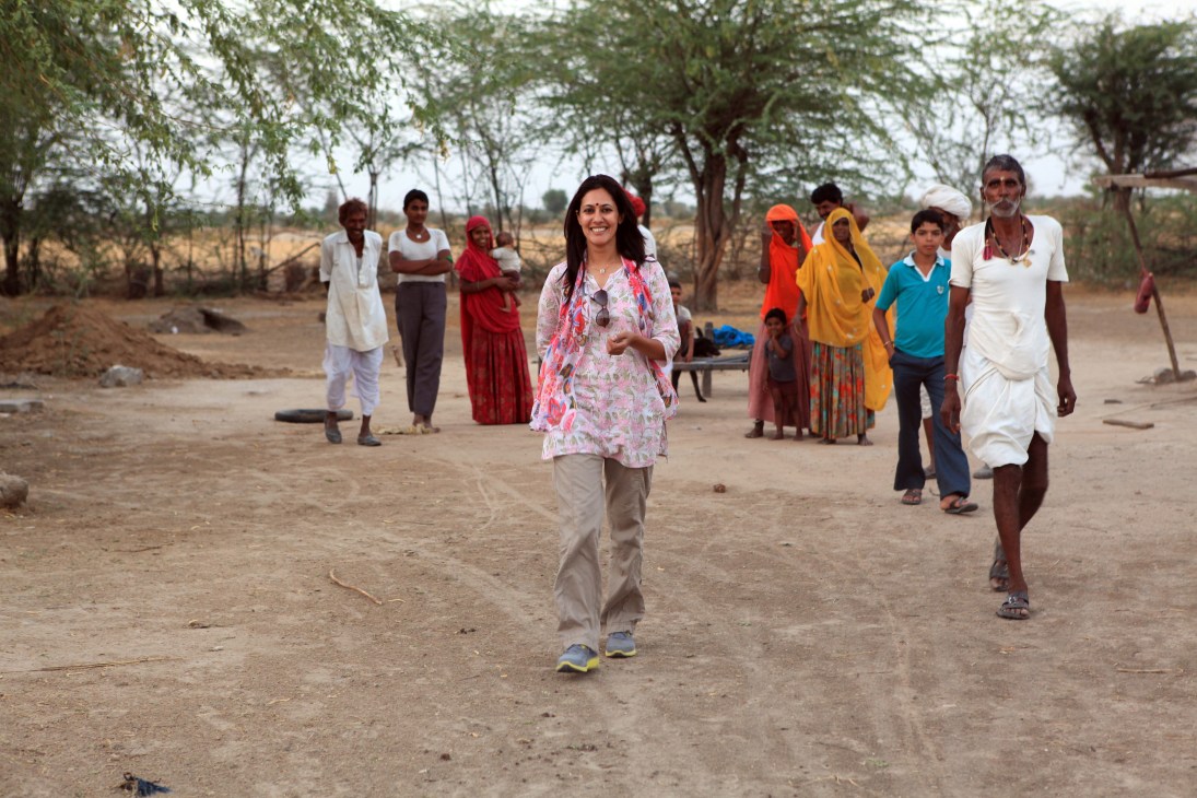 Chhavi Rajawat walking through Soda village with local residents gathered around her.