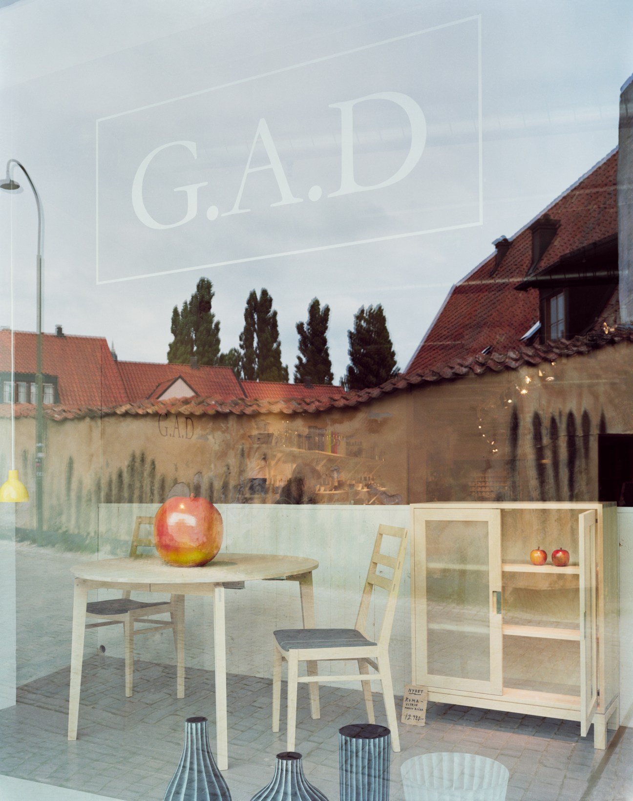 G.A.D shop storefront in Visby displaying wooden furniture and design objects behind glass.