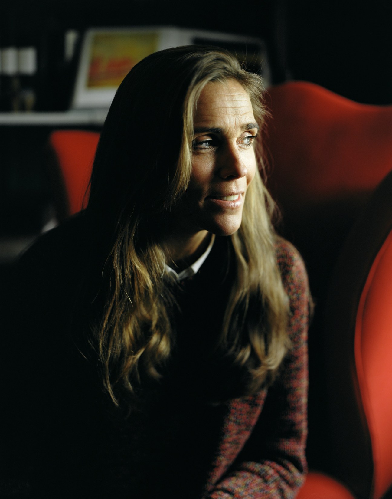 Jeanette Mix, owner of Stockholm's Ett Hem hotel, seated indoors with red chair visible behind her.