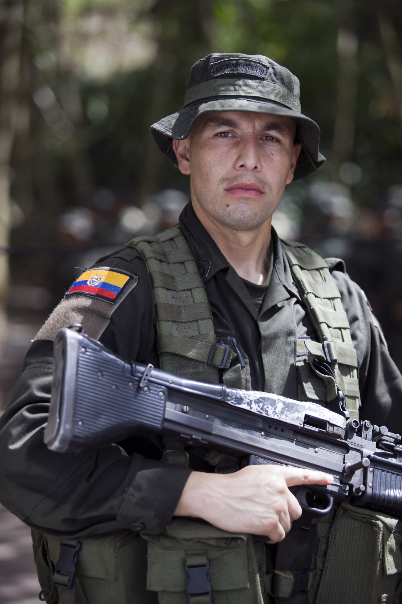 Ecuadorian police student in tactical gear holding an assault rifle during training.