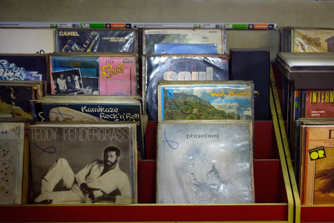 Vintage vinyl records and albums displayed on red shelving, including titles like Kamikaze Rock'n'Roll and Teddy Pendergrass.