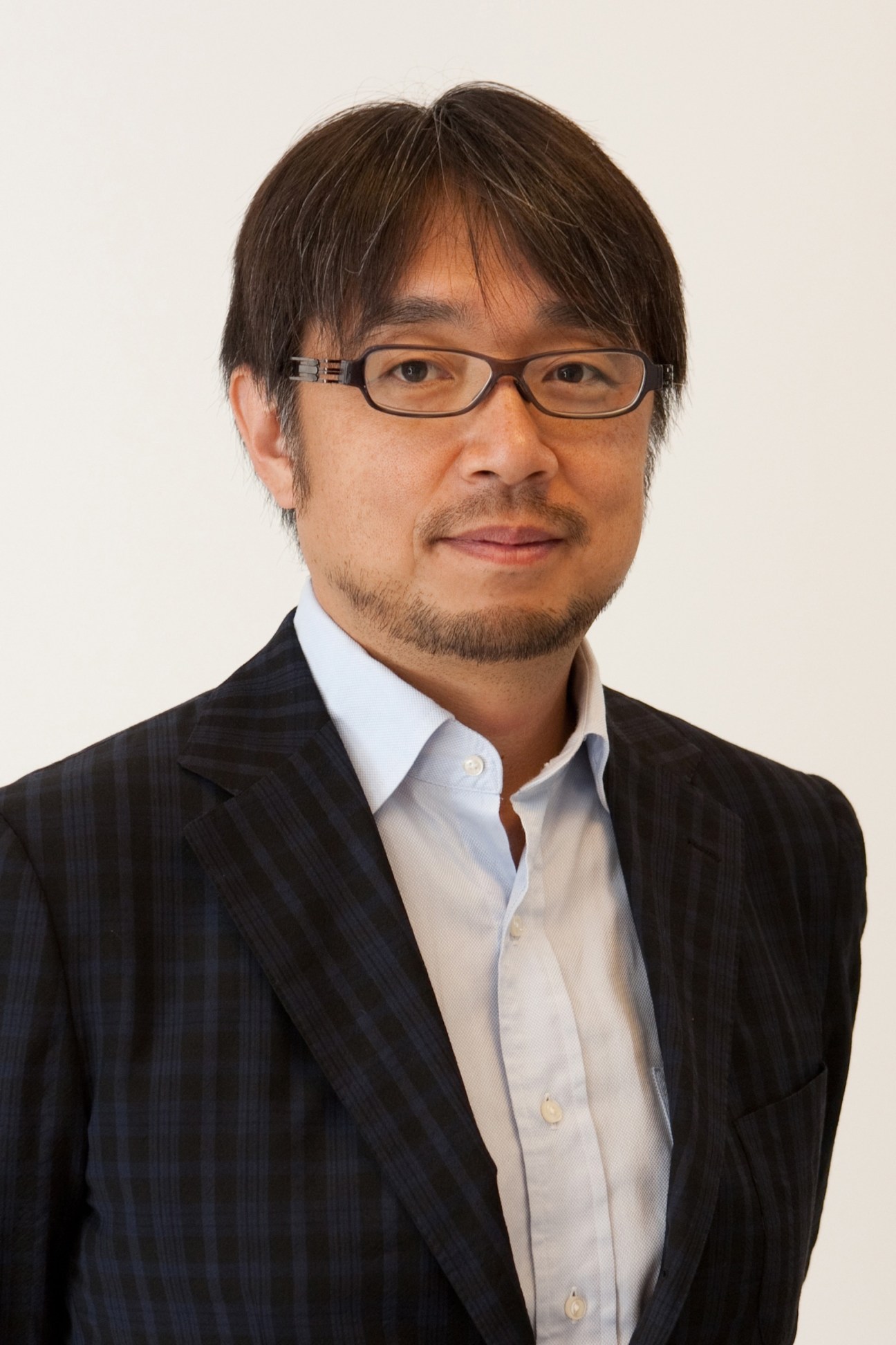 Portrait of Kundo Koyama, brand strategist for Marché Japon farmers' markets, wearing glasses and business attire.