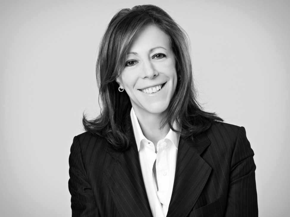 Jane Rosenthal, Tribeca Film Festival co-founder and producer, smiling in a black blazer and white shirt against a light background.