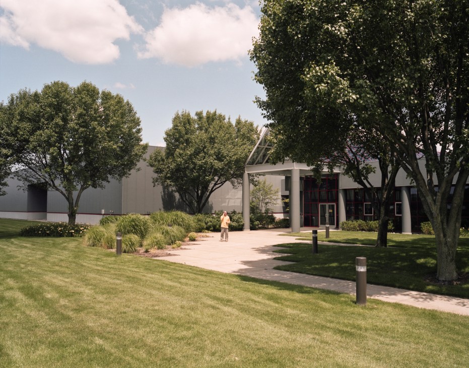 Herman Miller's headquarters exterior with modernist architecture, mature trees, and manicured lawn in Zeeland, Michigan.