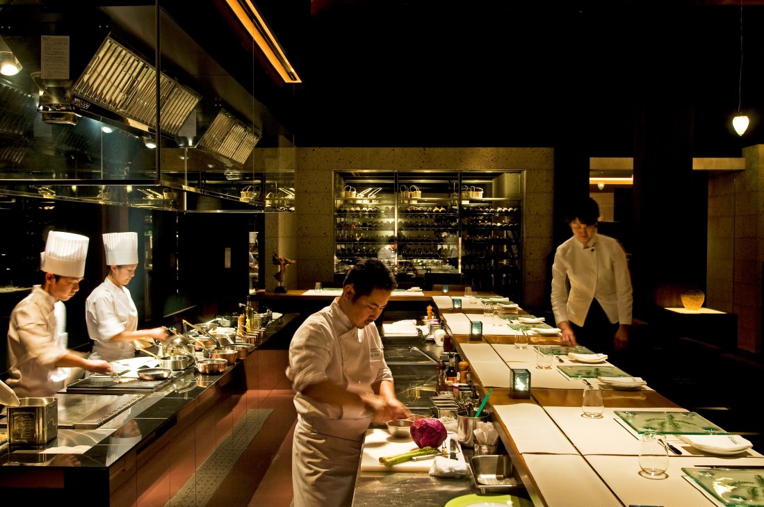 Chefs prepare dishes in the open kitchen at Okas restaurant at Sankara Hotel & Spa.