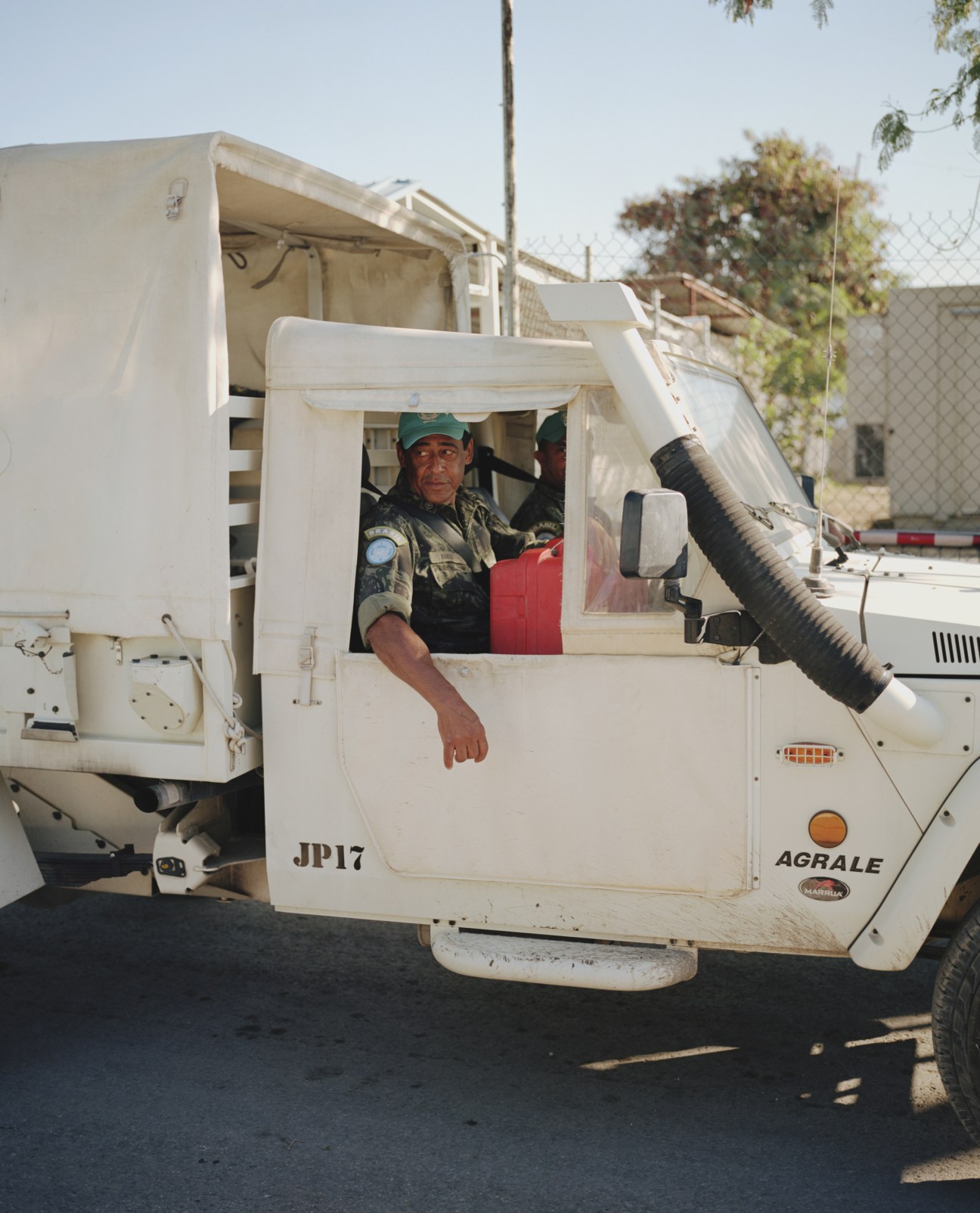 Brazilian military personnel in a white fumigation truck marked JP17 and AGRALE.