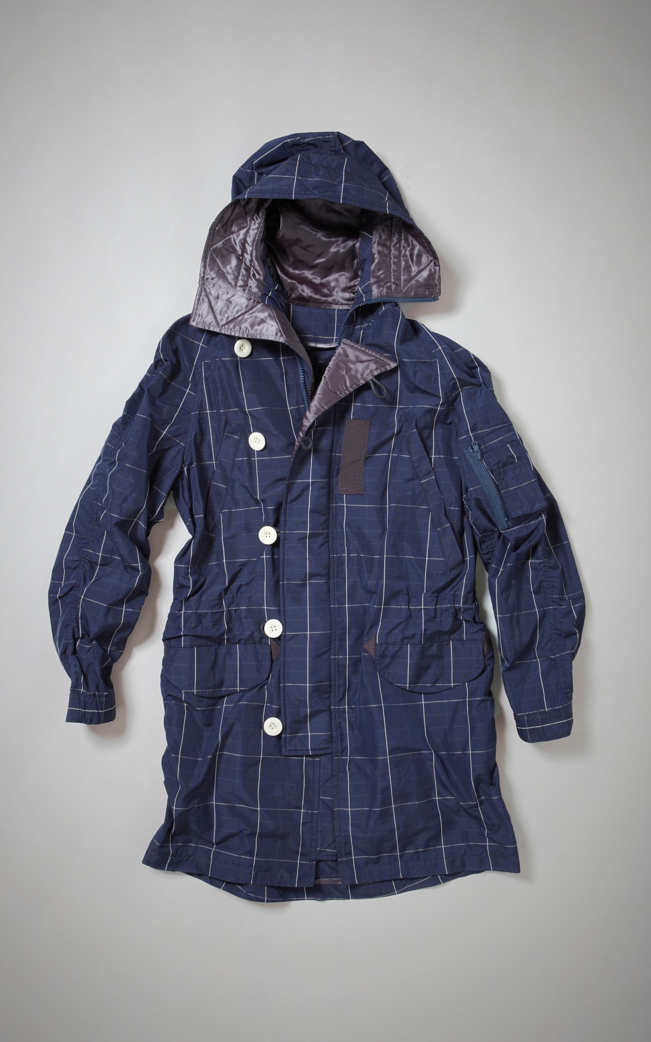 Navy blue quilted jacket with white grid pattern and metallic gray lining displayed flat against white background.