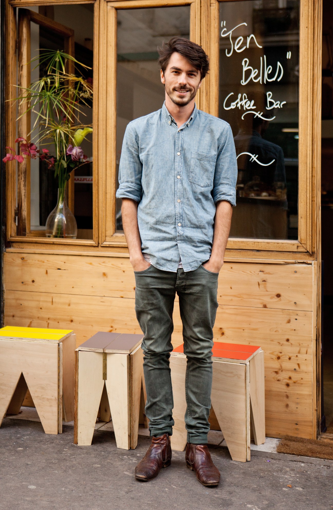 Thomas Lehoux stands outside Ten Belles coffee bar in Paris, wearing a light blue denim shirt.