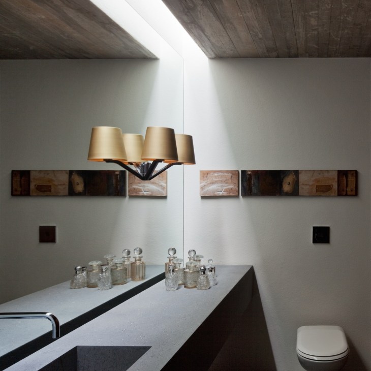 Minimalist washroom with pendant lamp, wall-mounted shelves, and modern fixtures.