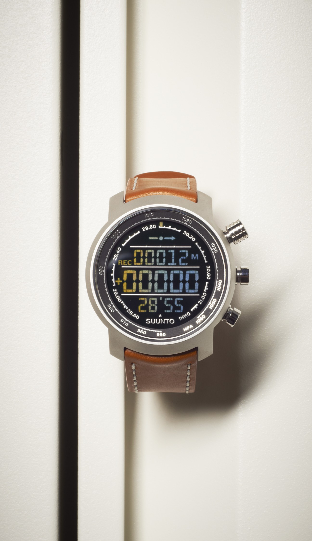 Suunto Elementum Terra watch with brown leather strap and digital display on white background.