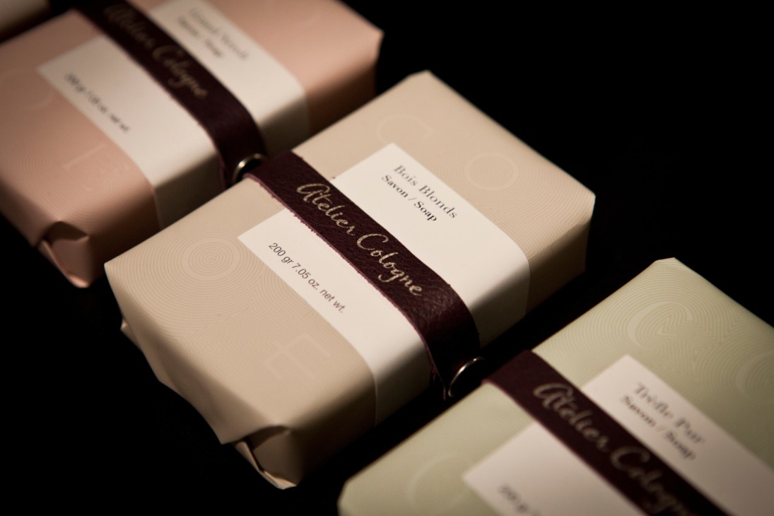 Atelier Cologne soap bars with cream packaging and dark ribbon bands.