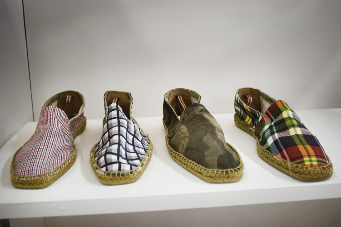 Four Castañer espadrilles with varied patterns displayed on a white shelf.